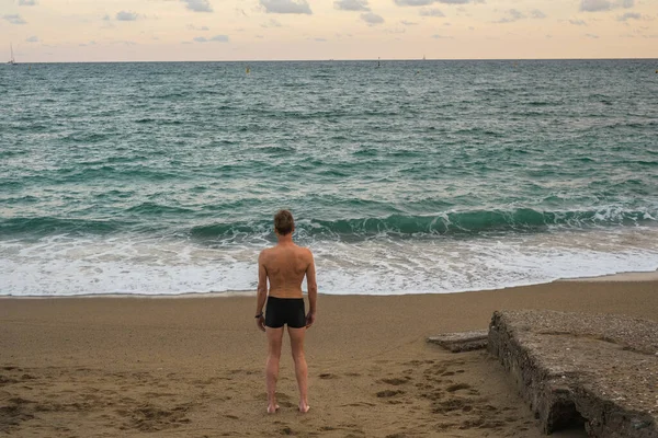 stock image lonely male swimmer looking at the sea view from the back