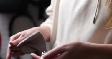 woman wiping smart watch with microfiber close-up of hands