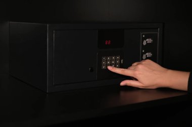 Kadının eli kasanın şifresini giriyor.