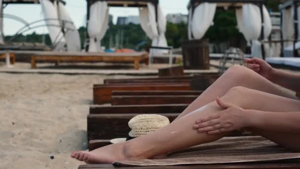 Una Giovane Donna Sta Riposando Prendendo Sole Lettino Spalmando Gambe — Video Stock