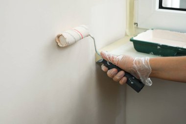 Kadın ressam elleriyle duvarları boyuyor.