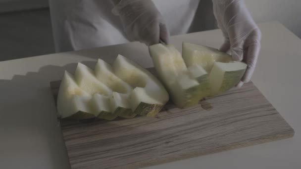 Zbliżenie Rąk Kucharza Rękawiczkach Ochronnych Pokrojenie Melona Drewnianej Płycie Log — Wideo stockowe