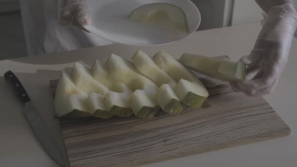 장갑에 요리사의 클로즈업 접시에 멜론을 비디오 — 비디오
