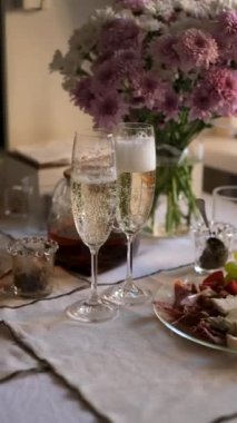 Bir adam şenlik masasından bir bardak şampanya alır.