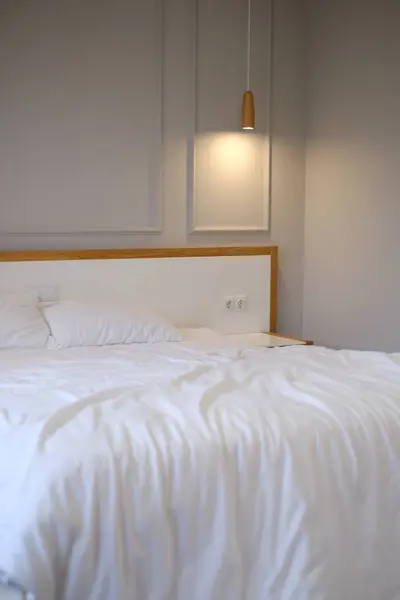 white bed linen on a large bed in a bright Scandinavian interior