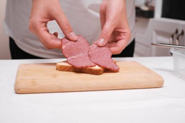 Kadın jambonlu tost hazırlıyor.