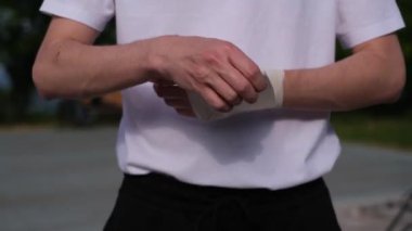 Sporcu boks yapmadan önce ellerini elastik bir bandajla sarar.