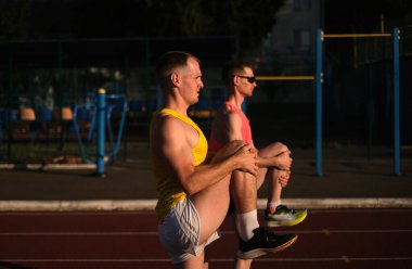 Yarıştan önce iki koşucu sahada ısınıyor.