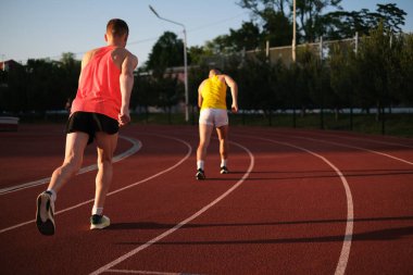 Sporcular stadyumda koşmada yarışıyorlar.