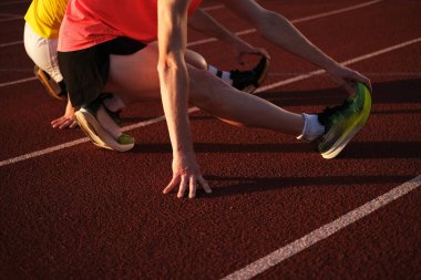 Sporcular stadyumda koşmadan önce ısınıyorlar