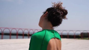 Güzel kadın yoga eğitmeni deniz kıyısındaki bir paspasın üzerinde egzersiz yapıyor.