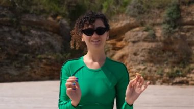 Spor giysili kıvırcık kadın güneş gözlüğü takıyor.