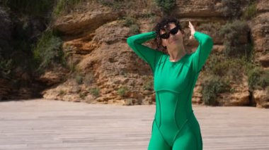 Sporcu kıvırcık kadın antrenmandan önce at kuyruğunu bağlar.