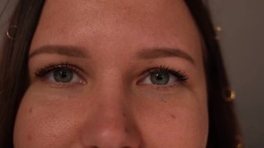 Hızla göz kırpan genç bir kadının gri gözlerini kapat.