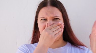 Burnunu nahoş bir kokudan koruyan şişman bir kadının portresi.