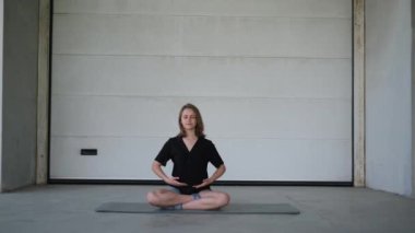 Güneşli bir yaz gününde spor minderinde nefes egzersizi yapan güzel bir kadının portresi.