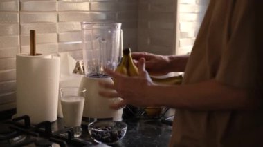 Meyve suyu yapmak için muz soyan bir adam.