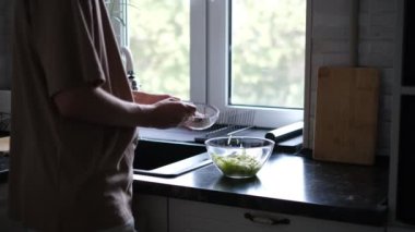 Bir adam rendelenmiş kabakla krep hazırlar.