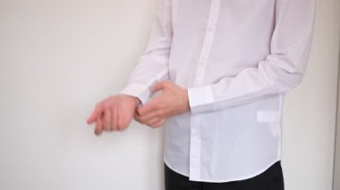 Genç adam beyaz gömleğinin kollarını sıvadı.