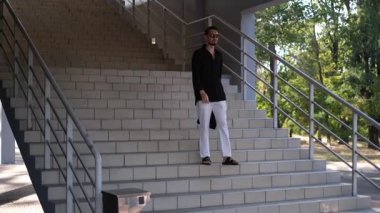 Genç erkek müdür işten sonra bir iş merkezinin merdivenlerinden aşağı iniyor.