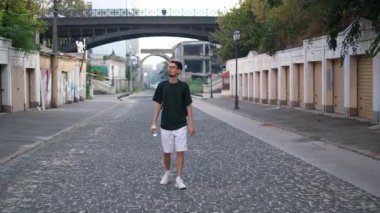 Genç adam eski harabe Avrupa şehrinde yürüyor yaz günü