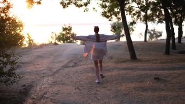 Tepeden tırnağa koşan genç kadın güneşin doğuşunun tadını çıkarıyor.