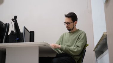 Genç erkek öğretmen iş yerindeki not defterine not alıyor.