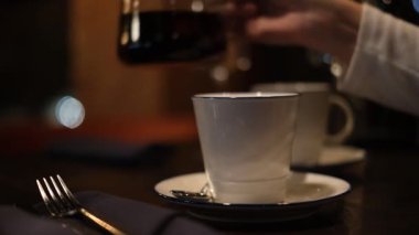 Restoranda çay içen genç bir kadın.