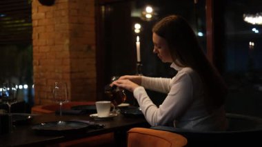 Restoranda çay içen genç bir kadın.