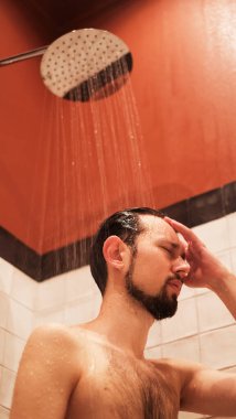 Genç adam sabah işe gitmeden önce duş alıyor.