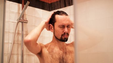 Genç adam sabah işe gitmeden önce duş alıyor.