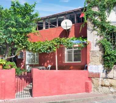 İşlenmiş demir pencereler, dağcı santralleri ve yeşil ağaçlar, Balat ilçesi, İstanbul ve Türkiye 'de bulunan eski kırmızı boyalı geleneksel konut evinin dış cephesi