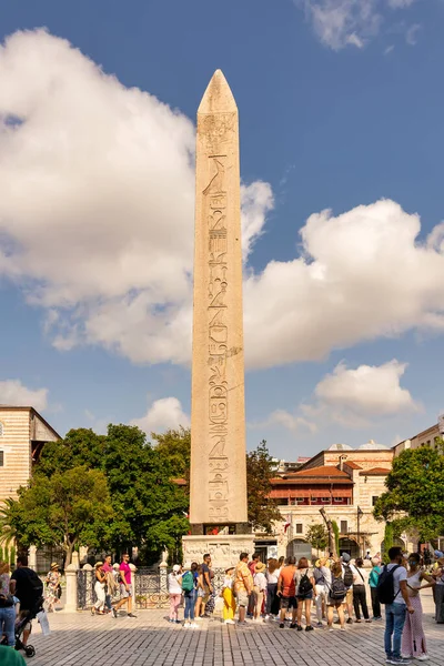 İstanbul, Türkiye - 30 Ağustos 2022: Theodosius 'un Obelisk' ini ziyaret eden turistler, Firavun Thutmose III 'ün antik Mısır dikilitaşları İstanbul Hipodromu veya Sultanahmet Meydanı' nda yeniden dikildi 