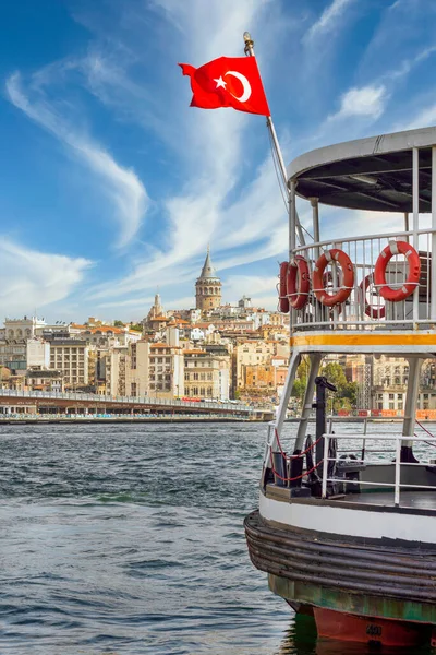 Eminonu feribot terminali, İstanbul 'un silueti Türkiye' de, arka planda Galata Kulesi ve Galata Köprüsü 'nün de bulunduğu Eminonu feribot iskelesine kenetlenmiş Türk bayrağı.