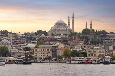 İstanbul, Türkiye - 25 Ağustos 2022: Eminonu 'daki Galata Köprüsü' nden feribot, feribot terminali ve gün batımından önce Süleyman Camii 'ne bakan İstanbul kent manzarası