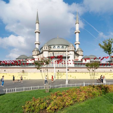 İstanbul, Türkiye - 2 Eylül 2022: İstanbul şehir merkezindeki Taksim Meydanı 'nda güneşli bir yaz gününde Taksim Camii önünde yürüyen turistler ve yerliler