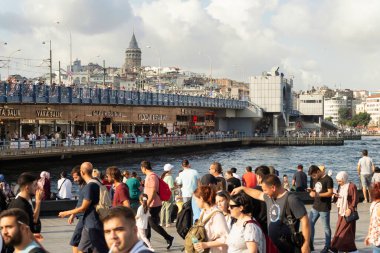 İstanbul, Türkiye - 30 Ağustos 2022: Galata Köprüsü 'ne bakan Eminonu Meydanı, köprünün altındaki geçitte geleneksel balık restoranları, Galata Kulesi ve Zafer Günü boyunca kalabalık