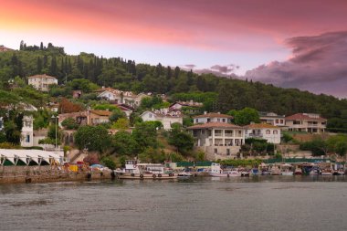 Marmara Denizi 'nden Kinaliada adasının dağlarının manzarası, geleneksel yazlık evler ve rıhtımlı tekneler, gündoğumunda İstanbul, Türkiye