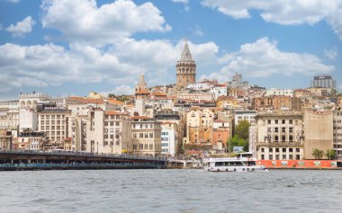 İstanbul, Türkiye - 25 Ağustos 2022: Köprünün altındaki geçitte geleneksel balık restoranları bulunan Galata Köprüsü ve uzak uçtaki Galata Kulesi de dahil olmak üzere şehir silüeti