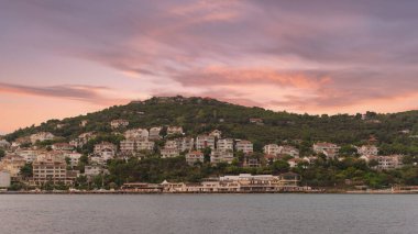 View of the mountains of Kinaliada island from Marmara Sea, with traditional summer houses and boats, Istanbul, Turkey, at sunrise