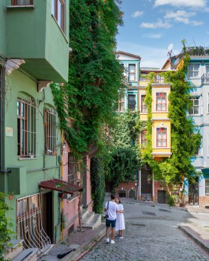 Istanbul, Turkey - August 28, 2022: Taditional colorful old houses in old Balat district, with few pedestrians, in a summer day