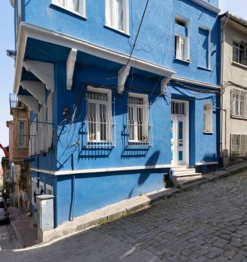 Eski Balat ilçesinde eski güzel mavi boyanmış evi olan kaldırım taşı sokak, bir yaz günü, İstanbul, Türkiye