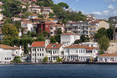 İstanbul ve Türkiye 'de yaz günlerinde geleneksel evler ve sık ağaçlarla, Asya yakasının yeşil dağlarının İstanbul Boğazı' ndan görüntüsü
