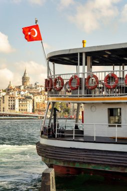Eminonu feribot terminali, İstanbul 'un silueti Türkiye' de, arka planda Galata Kulesi ve Galata Köprüsü 'nün de bulunduğu Eminonu feribot iskelesine kenetlenmiş Türk bayrağı.