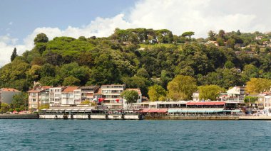 View from the sea of the green mountains of the Europian side of Bosphorus strait, with traditional houses and dense trees in a summer day, Istanbul, Turkey