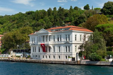 İstanbul ve Türkiye 'de yaz günlerinde geleneksel evler ve sık ağaçlarla, Asya yakasının yeşil dağlarının İstanbul Boğazı' ndan görüntüsü