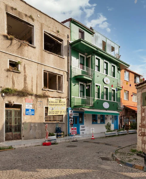 stock image Istanbul, Turkey - August 30, 2022: Cobblestone alley, with beautiful old colorful traditional house, painted in green, suited in Kapiagasi Street, Fatih district, in a summer day