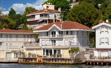 İstanbul ve Türkiye 'de yaz günlerinde geleneksel evler ve sık ağaçlarla, Asya yakasının yeşil dağlarının İstanbul Boğazı' ndan görüntüsü