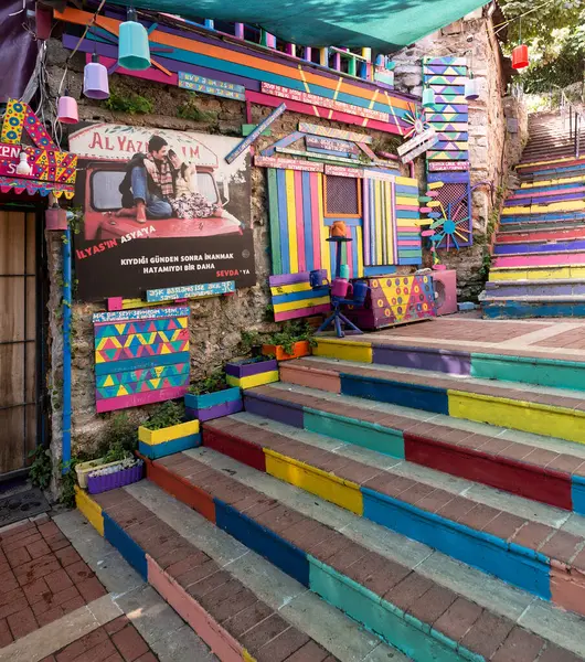 stock image Exterior daytime shot of stone cafe decorated with multicolored panels colorful stairs, and canopy in Balat District, Istanbul, Turkey