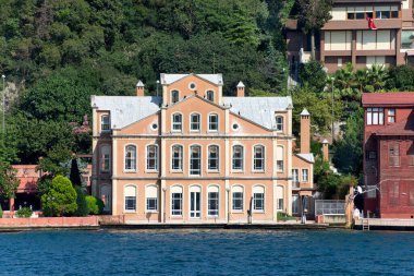 İstanbul ve Türkiye 'de yaz günlerinde geleneksel evler ve sık ağaçlarla, Asya yakasının yeşil dağlarının İstanbul Boğazı' ndan görüntüsü